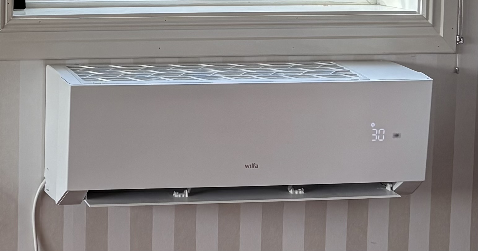 Hvit Wilfa-varmepumpe med diskret LED-display og avrundet design.